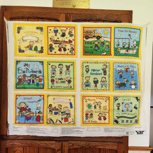 May include: A vibrant fabric panel with school-themed illustrations. The panel is divided into squares with yellow and green borders, each showcasing scenes of school life, such as children, a school bus, and text including "First Day of School" and "School Supplies".