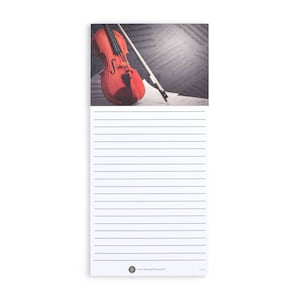 May include: A lined notepad with a red violin and bow on a sheet of music. The notepad has a white background with black lines. The music sheet is gray with black notes.