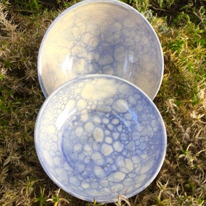 May include: Two ceramic bowls with a blue and white bubble pattern. The bowls are nested together.
