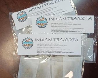May include: Several tea bags in clear plastic packaging. Each bag has a white label with the text "INDIAN TEA/COTA" and a circular logo. The labels also list ingredients and directions for use. The tea bags are filled with loose tea.
