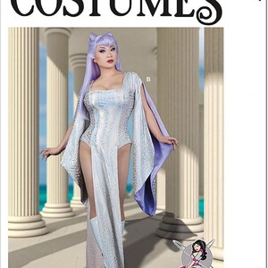 May include: McCall's Costumes pattern featuring a fantasy-themed outfit. The costume is a long, silver dress with a textured pattern, paired with a purple cape. The model is wearing a matching wig and boots. The pattern number is M8187.