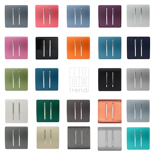 May include: A collection of 20 light switch covers in various colours, including grey, pink, orange, teal, green, and black. The switch covers have a modern design with two silver toggle switches.