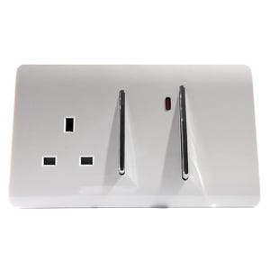 May include: A white rectangular wall plate featuring a three-pin electrical socket on the left side and two vertical light switches on the right. The switches have metallic silver edges, and a small red indicator light is visible above the right switch.