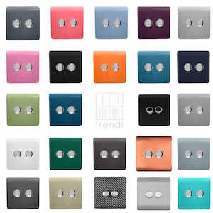 May include: A selection of light switch plates in a variety of colours, such as pink, blue, and black. Each plate has two round silver buttons. The brand name "trendi" is visible in the centre.