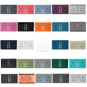 May include: A collection of 20 double electrical socket covers in various colours and finishes, including black, white, grey, green, orange, pink, teal, copper, and silver. The socket covers are all the same size and shape, and they feature a sleek, modern design. The text "trendi" is visible in the centre of the image.