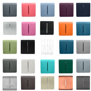 May include: A collection of twenty-five square light switches in various colours and finishes, each featuring a central vertical chrome toggle. The brand name trendi is printed in the centre with a grid logo above the text, surrounded by switches.