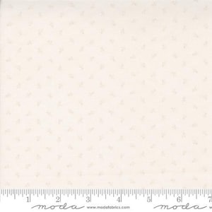 May include: Cream-colored fabric with a subtle, repeating floral pattern. The fabric has a textured appearance and a ruler along the bottom edge for scale. The floral design is a light beige color, creating a delicate and understated aesthetic.