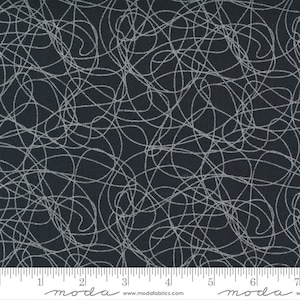 May include: Black fabric with a white scribble pattern. The fabric is shown with a ruler for scale.