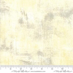 May include: A cream-colored fabric with a subtle gray and white distressed pattern. The fabric has a slightly textured surface and a soft, faded look.