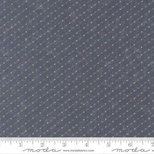 May include: A close-up of a fabric with a dark blue background and a pattern of diagonal lines of small, connected beige circles. The fabric has a textured appearance. A ruler is at the bottom of the image.
