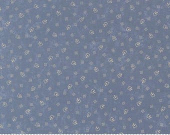 May include: Blue fabric with a repeating pattern of small, light beige shapes. The shapes include a square with a dot in the center and a small rectangle. A ruler is at the bottom of the image, with the word "moda" printed on it.