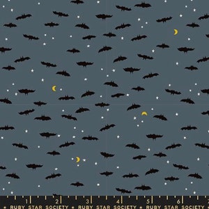 May include: A dark blue fabric with a repeating pattern of black bats and white stars. There are also small yellow crescent moons scattered throughout the fabric.