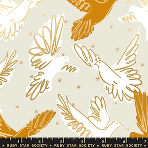 May include: A beige fabric with a repeating pattern of white and gold doves flying against a background of gold stars. The fabric is from Ruby Star Society.