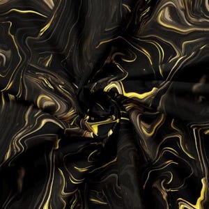 May include: Abstract fabric with a swirling pattern in black and gold. The design features flowing lines and a marbled effect, creating a luxurious and dynamic visual texture. The fabric appears to be folded, adding depth to the design.