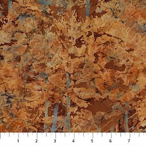 May include: A fabric with a mottled pattern in shades of brown, tan, and blue. The design resembles a textured surface with irregular shapes and streaks. A ruler is visible along the bottom, marked in inches.