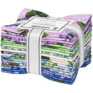 May include: A stack of fat quarter fabric bundles tied with a white ribbon. The fabric features a floral pattern in shades of purple, blue, green, and white. The label reads "Complete Collection Fat Quarters".