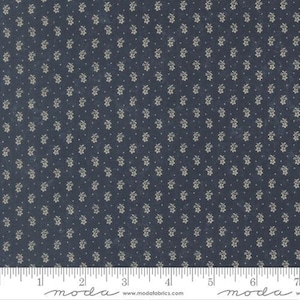 May include: Dark blue fabric with a repeating pattern of small, cream-colored floral clusters and dots. The fabric is measured with a ruler marked in inches. The fabric is likely used for quilting or other craft projects.