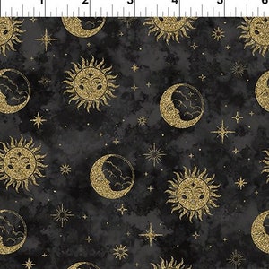 May include: A black fabric with a gold glitter pattern of suns, moons, and stars. The suns and moons have faces.