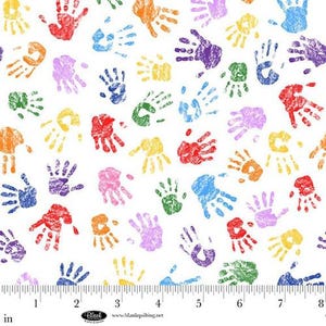May include: White fabric with a repeating pattern of colorful handprints in red, orange, yellow, green, blue, purple, and pink. The handprints are evenly spaced across the fabric. A ruler is at the bottom, marked in inches.