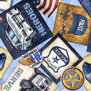 May include: A blue and white fabric with a variety of police-themed patches. The patches feature images of police cars, badges, and text such as "Highway Patrol", "Police", "Support Our", "Crime Scene", "CSI", and "Heroes".
