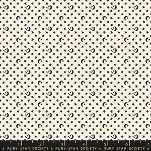 May include: A white fabric with a repeating pattern of black stars and crescent moons. The fabric has a ruler at the bottom with the text "Ruby Star Society" repeated.