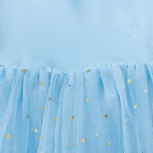 K&ouml;nnte beinhalten: Hellblaues Kleid mit T&uuml;llrock. Der T&uuml;ll ist mit goldenen Sternen und Monden verziert. Das Oberteil des Kleides besteht aus einem einfarbigen hellblauen Stoff.