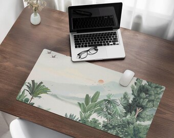 May include: A large desk mat with a tropical landscape design. The mat features a sunset over a lake with palm trees and other foliage. The mat is light beige with green and brown accents.