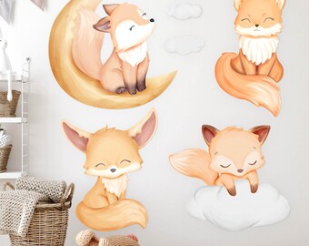 May include: A collection of whimsical fox wall decals in shades of orange and cream. One fox sits on a crescent moon, others on clouds. The decals are designed for a nursery or children's room, creating a playful and comforting atmosphere.