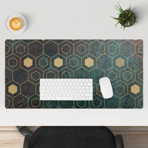 Op de afbeelding: Een bureau mat met een teal en gouden geometrisch patroon met een wit toetsenbord en muis erop.