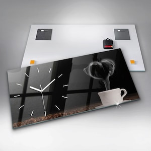 May include: A black and white clock with a white cup of coffee and steam rising from it. The clock is set against a background of coffee beans.