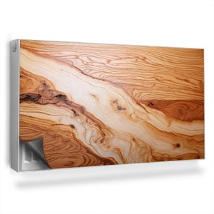 Op de afbeelding: Een close-up van een houten radiatorbekleding met een natuurlijk houtnerfpatroon. De bekleding is gemaakt van lichtbruin hout met donkerbruine strepen en knoesten. De bekleding is ontworpen om over een radiator te passen en kan worden gebruikt om de esthetiek van een kamer te verbeteren.