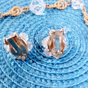 May include: A pair of silver clip-on earrings with clear crystal accents. The earrings have a simple design and are perfect for everyday wear.