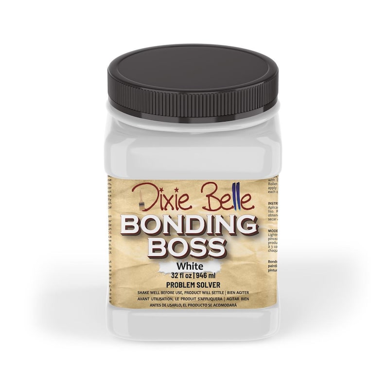 May include: A white plastic bottle with a black lid labelled "Dixie Belle Bonding Boss White 32 fl oz 1946 ml Problem Solver". The label has a brown, textured background and the text is in a black font.