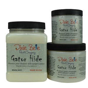 May include: Three containers of Dixie Belle Paint Company Gator Hide, a clear protective topcoat. The containers feature black screw-on lids and labels with the text Gator Hide, Protect your creation with nature's armor, and Made in USA.