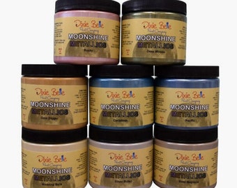 May include: A set of ten 4 oz jars of Dixie Belle Moonshine Metallic paint. The jars are arranged in two rows of five. The colors are: Rozay, Deep Woods, Gold Digger, Caribbean, Pacific, Wedding Belle, Silver Bullet, and Steel Magnolia.