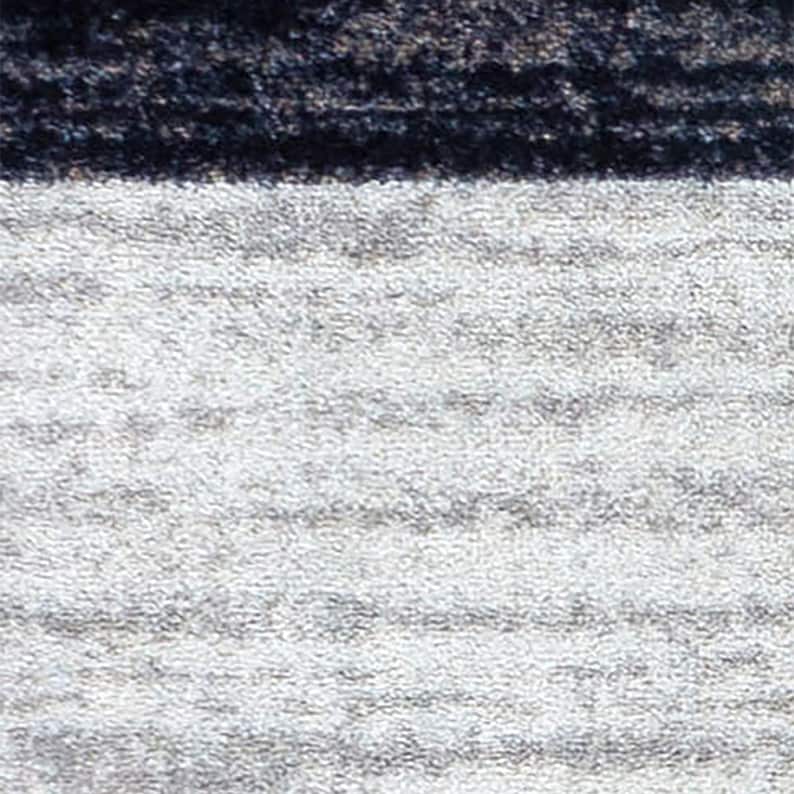 May include: A textile surface featuring a horizontal color-blocked design. The upper section consists of a dark, textured charcoal black band, while the lower, larger portion displays a light gray, mottled, and slightly heathered fabric texture.