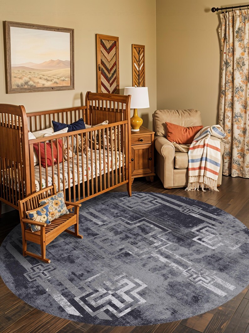 May include: A large, circular area rug featuring a distressed, dark grey and charcoal colour palette with a repeating geometric pattern of light grey, angular, cross-like motifs and linear borders across the entire textured surface.