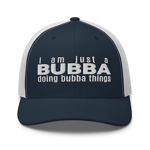Könnte beinhalten: Eine marineblaue und weiße Trucker-Kappe mit dem gestickten Text "I am just a BUBBA doing bubba things" in Weiß.