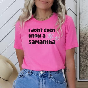 Pode incluir: Camiseta rosa com o texto "I don't even know a Samantha" e dois gráficos de flocos de neve.