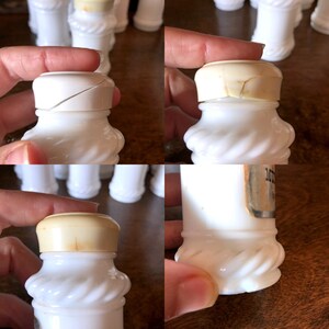 May include: A set of white milk glass bottles with twisted designs and cork tops. The bottles are vintage and have a label on one of them that reads "Milk of Magnesia".