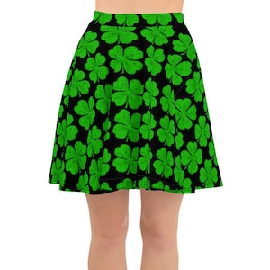 May include: A black skater skirt with a green four-leaf clover pattern.