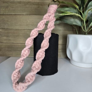 May include: A pink braided keychain with a gold metal key ring. The keychain is made of cotton rope and is approximately 25 cm long.