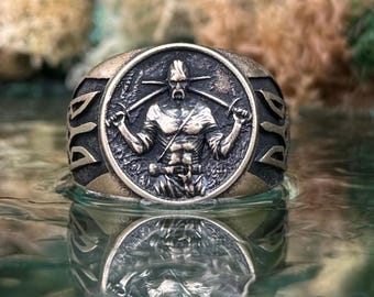 May include: A bronze-toned metal ring featuring a circular centerpiece with a relief of a warrior holding two crossed swords. The band displays intricate geometric cutouts on the sides, with a dark, weathered finish highlighting the detailed engraving.