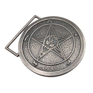 May include: A circular silver-toned metal belt buckle featuring a raised pentagram design with a central goat head motif. The background of the circle has a textured, hammered finish, and Hebrew characters are engraved along the outer edge.