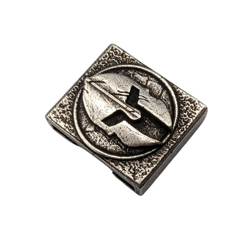 May include: Silver-toned metal square charm with a raised, detailed design of a Spartan helmet.