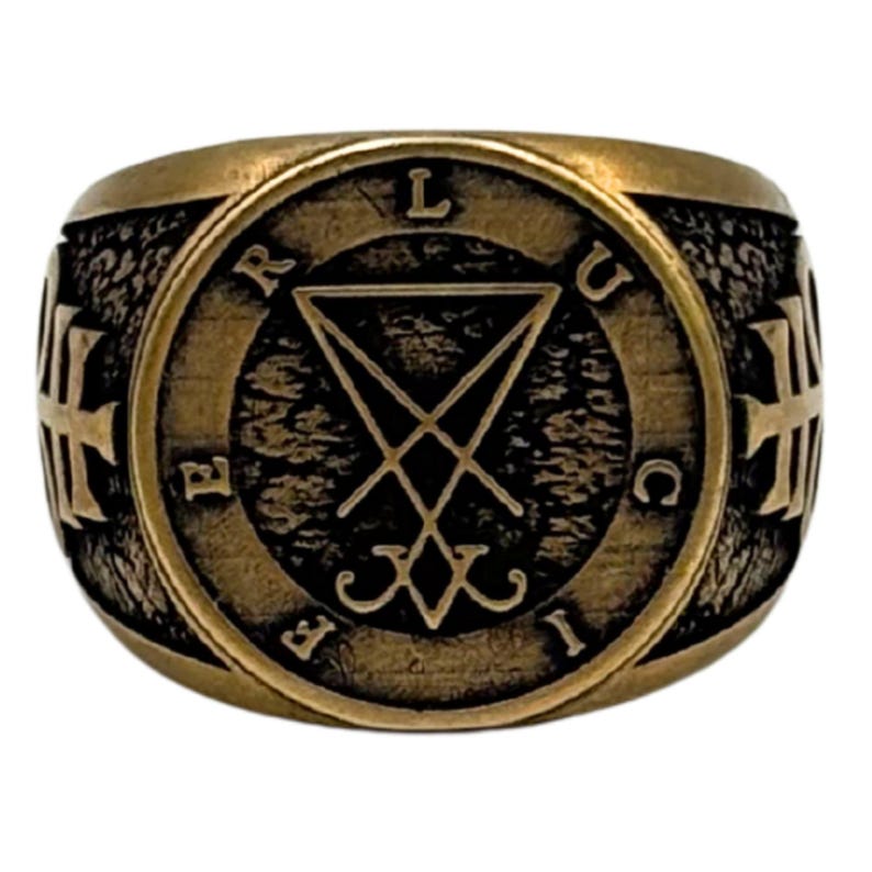 May include: A bronze-toned metal ring featuring a circular face with a textured dark background. The center displays a sigil of Lucifer, surrounded by the letters L, U, C, I, F, E, R. The sides of the ring band are adorned with embossed cross symbols.