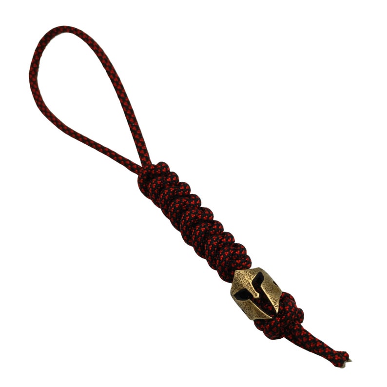 May include: A red and black paracord keychain with a brass Spartan helmet charm.