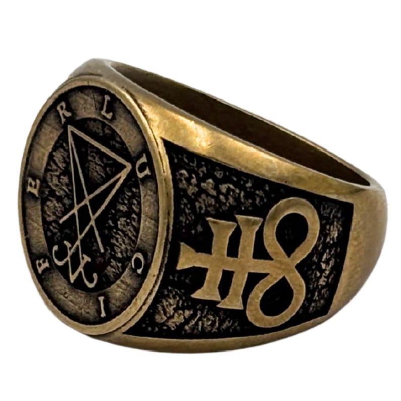 May include: A brass-toned metal ring featuring a circular face with the engraved sigil of Lucifer and the letters F, E, R, L, U, C, I arranged around the border. The side of the ring displays a raised, textured black background with a gold symbol.