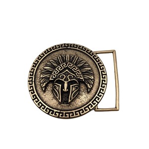 May include: A circular belt buckle with an antique bronze finish featuring a central embossed Spartan helmet design. The outer edge is decorated with a repeating Greek key pattern, and a rectangular loop is attached to the right side.