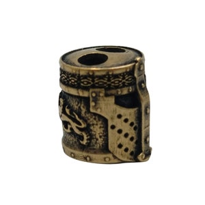 May include: A bronze-colored metal bead shaped like a knight's helmet with a lion design on the side. The helmet has a visor and a decorative band around the top.